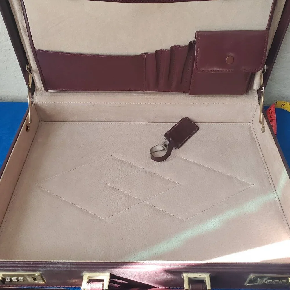 Burgundy leather attaché briefcase with a three-digit combination lock and gold-